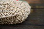 A close up of a knitted hat on a wooden surface