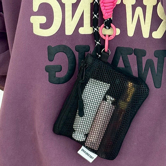 Black mesh coin purse makeup bag with pink lanyard and keychain holding cosmetics and cards